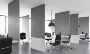 Side view of concrete coworking office interior design with laptops on workplaces, ceiling lamps and daylight. 3D Rendering